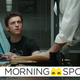 Tom Holland's Peter Parker looks up from a police document as an unseen figure in a shirt and tie slams down more paperwork.